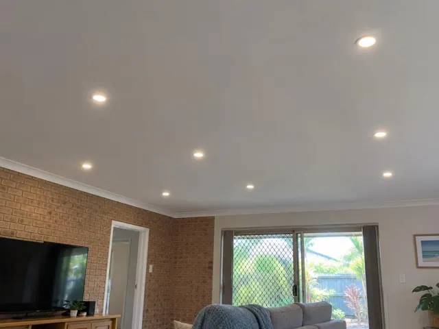 Ceiling downlights in a living room with brick walls and sliding glass doors in Coombabah